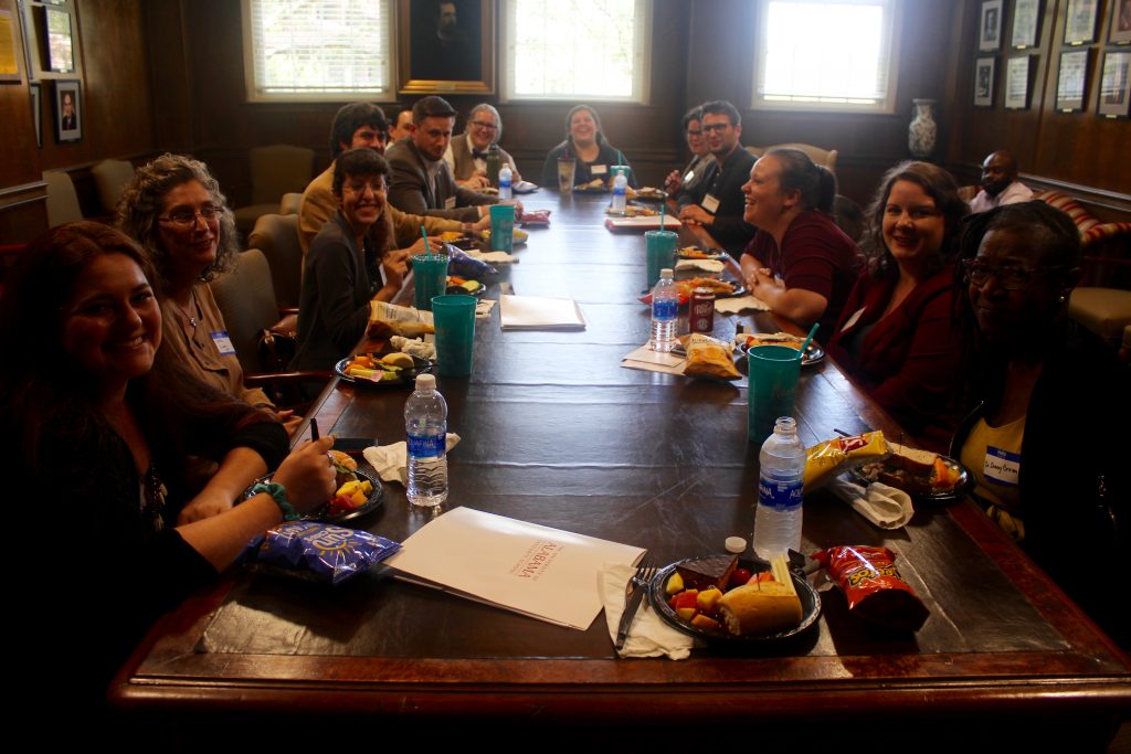 This image shows several graduate students eating lunch in the Summersell Room.