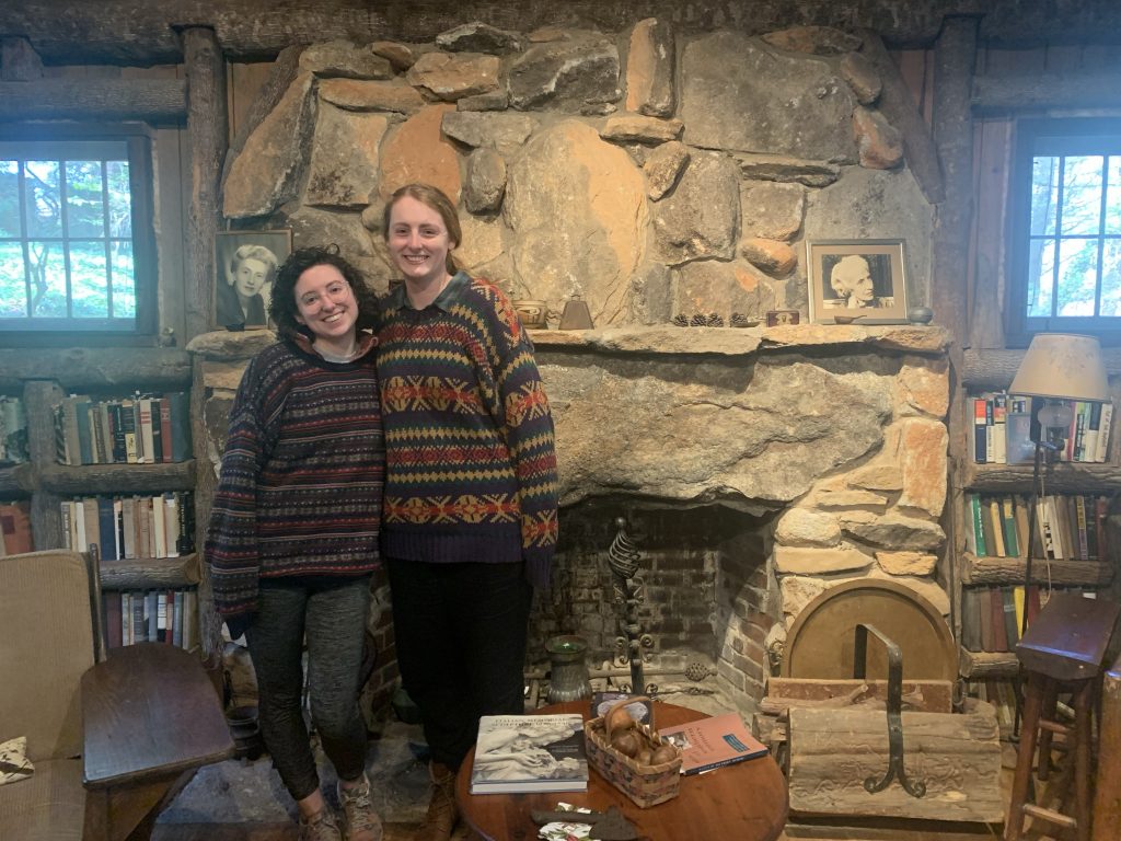 Pepper and Schultz standing in front of a fireplace.