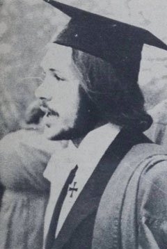 Black and white photo of Russell Bryant as a young man wearing his mortar board and academic gown.