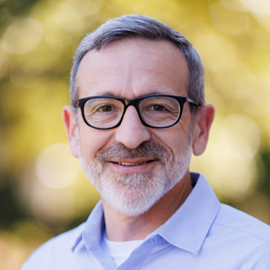 Joshua Rothman, sporting a closely-shaven beard, glasses, and a smile.