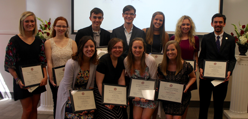 Undergraduate peer mentors are photographed receiving recognition plaques for their work.