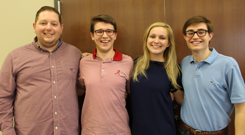 four history majors who are members of mock trial standing arm in arm.