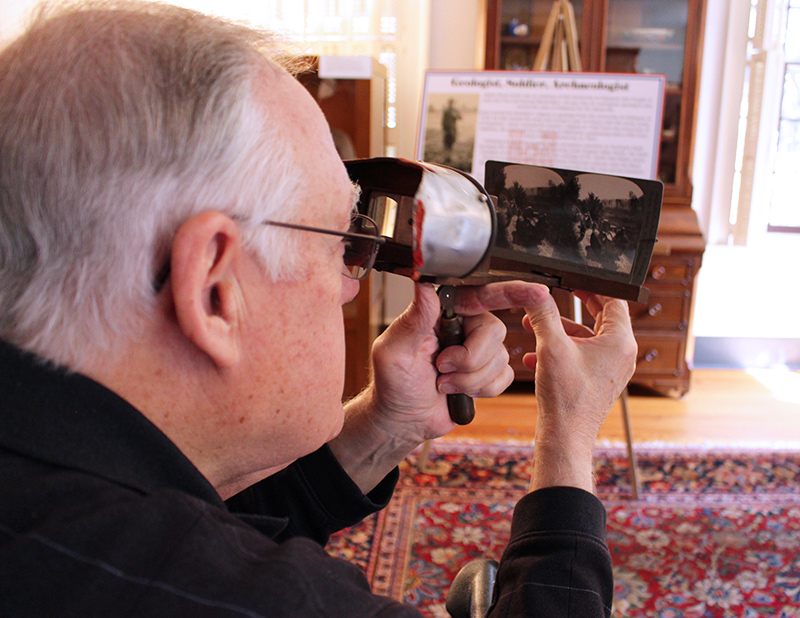 researcher viewing an old photo through a magnifying glass