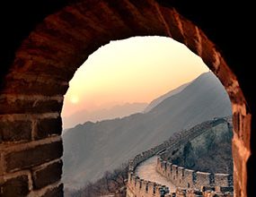 view of the sunset through an archway on the great wall of china