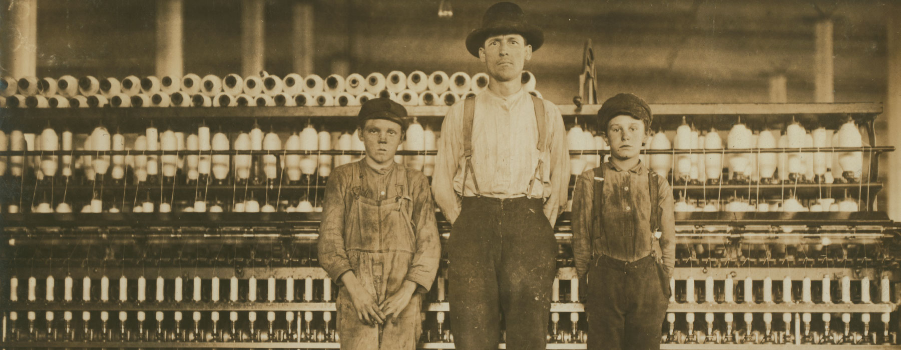 men and kids standing in a factory